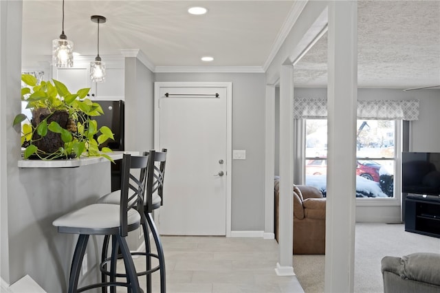 entrance foyer featuring light colored carpet, a textured ceiling, and ornamental molding