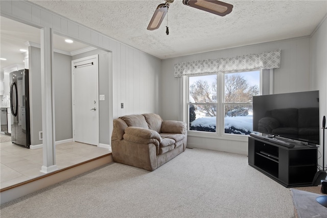 carpeted living room with a textured ceiling and ceiling fan