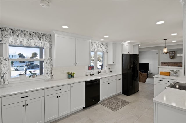 kitchen with black appliances, tasteful backsplash, white cabinetry, sink, and pendant lighting