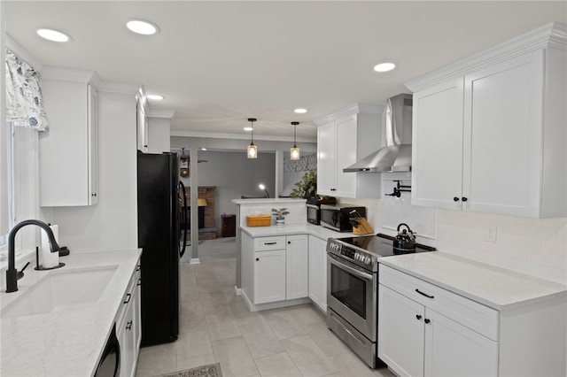 kitchen featuring black appliances, wall chimney exhaust hood, white cabinetry, sink, and hanging light fixtures