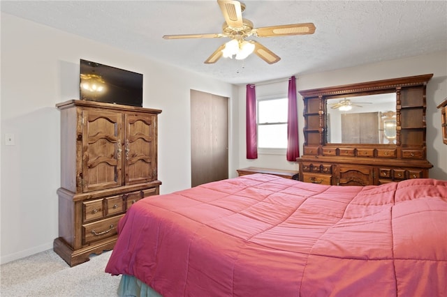 carpeted bedroom featuring ceiling fan and a textured ceiling