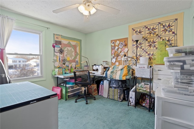 carpeted home office with ceiling fan and a textured ceiling