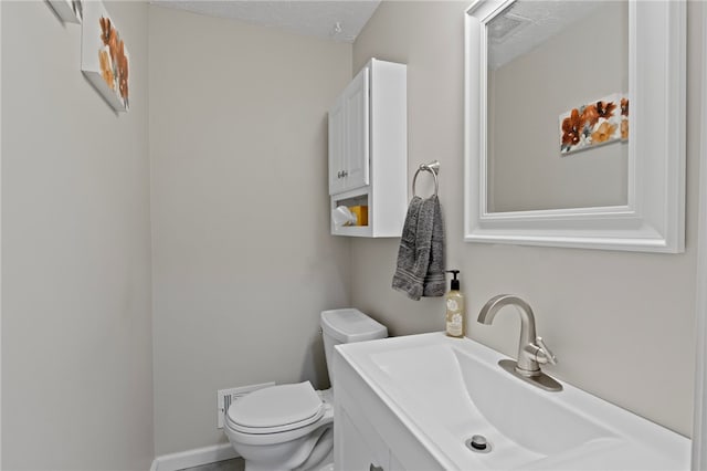 bathroom featuring vanity, toilet, and a textured ceiling