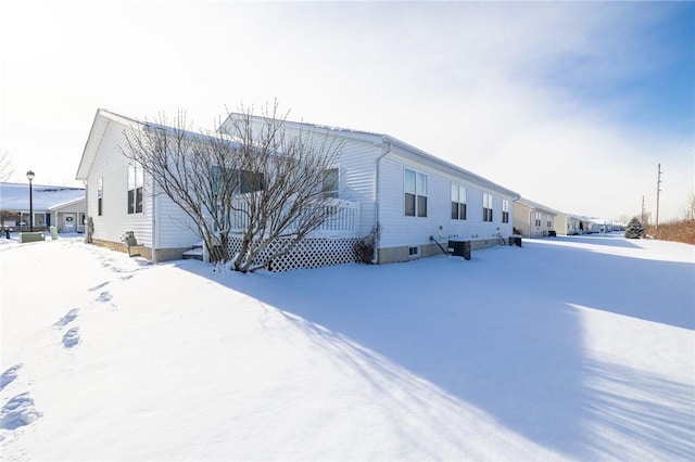 view of snow covered exterior with central AC unit