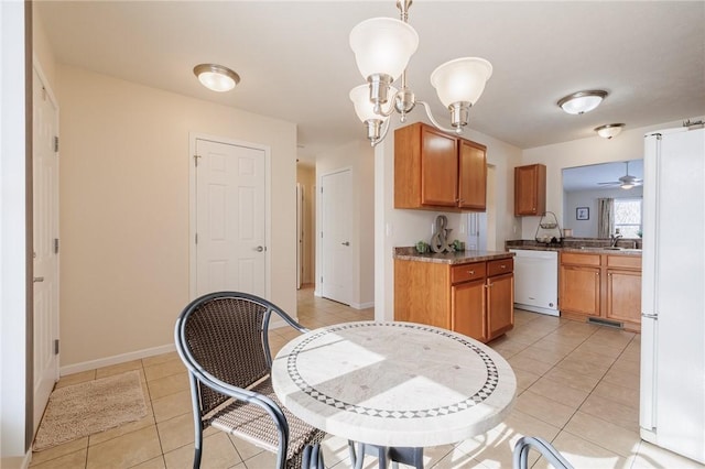 kitchen with pendant lighting, sink, white appliances, and light tile patterned floors