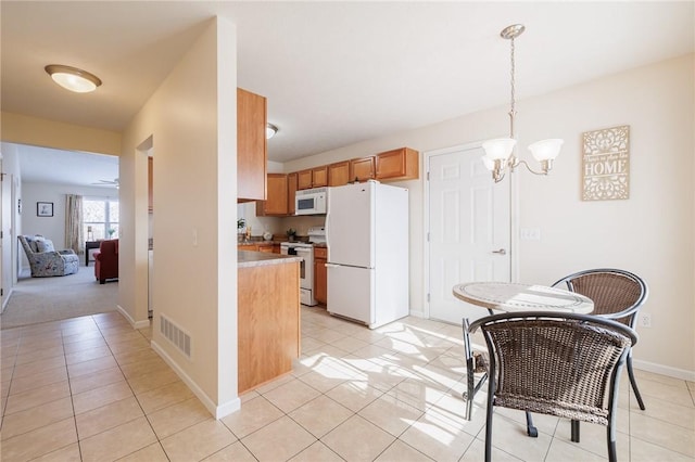 kitchen featuring ceiling fan with notable chandelier, light tile patterned flooring, white appliances, and pendant lighting