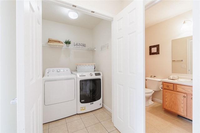 laundry room featuring washer and dryer and light tile patterned flooring