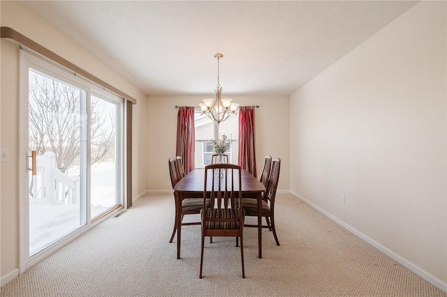 dining room featuring a chandelier, light colored carpet, and a wealth of natural light