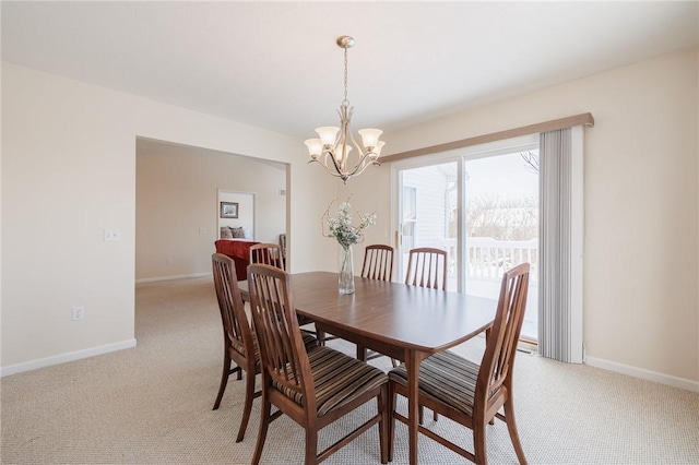 dining space with a chandelier and light colored carpet