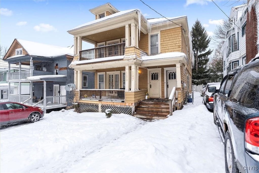 view of front of property with covered porch and a balcony