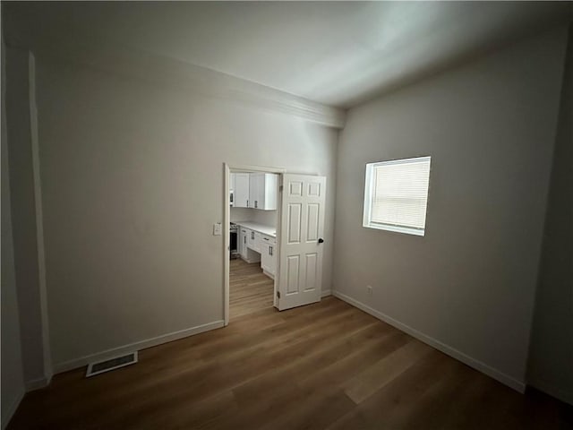 unfurnished bedroom featuring dark hardwood / wood-style flooring