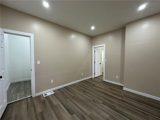 unfurnished room with dark wood-type flooring