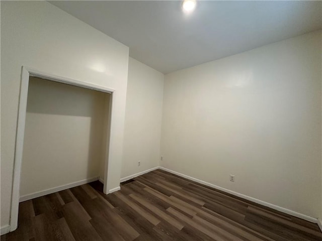 unfurnished room featuring dark wood-type flooring