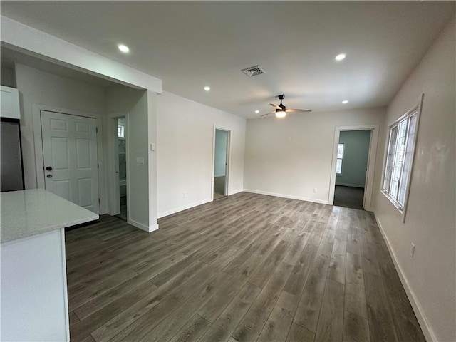 unfurnished living room with ceiling fan and dark wood-type flooring