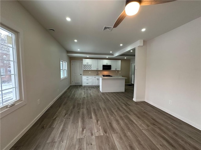 unfurnished living room with sink and dark wood-type flooring