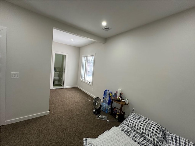 unfurnished bedroom featuring connected bathroom and dark colored carpet