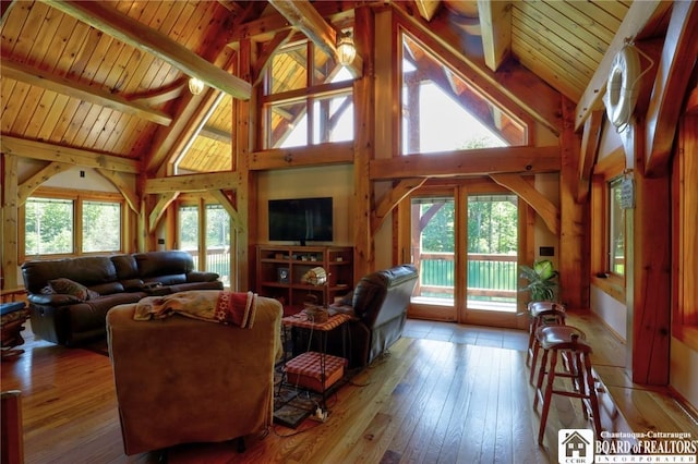 living room with wood ceiling, light wood-type flooring, high vaulted ceiling, beam ceiling, and plenty of natural light