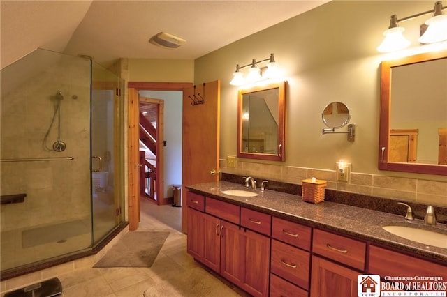 bathroom with tasteful backsplash, a shower with shower door, and vanity