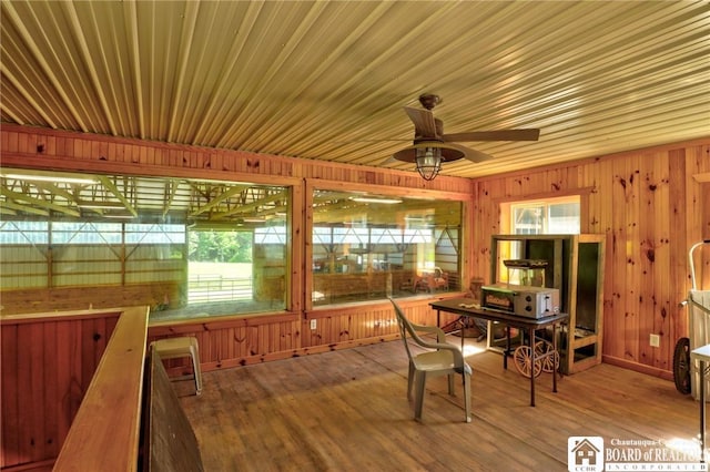 unfurnished sunroom featuring ceiling fan and a healthy amount of sunlight