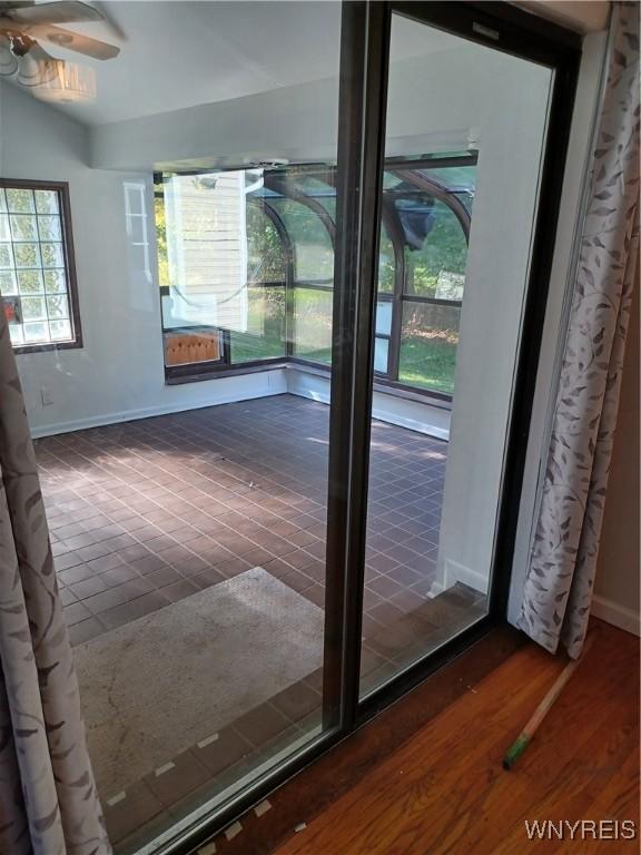 interior space with ceiling fan, dark wood-type flooring, and vaulted ceiling