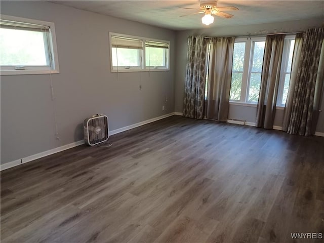 spare room with ceiling fan, a healthy amount of sunlight, and dark hardwood / wood-style floors