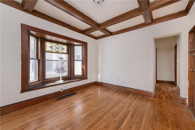 spare room with coffered ceiling, hardwood / wood-style flooring, and beam ceiling