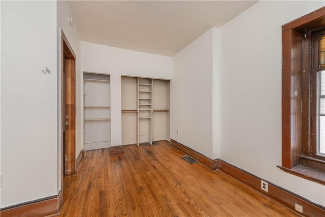 unfurnished bedroom featuring a closet and hardwood / wood-style floors