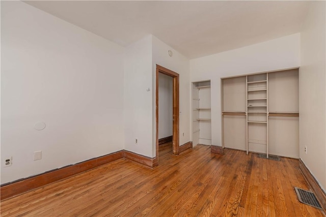 unfurnished bedroom featuring hardwood / wood-style flooring and a closet