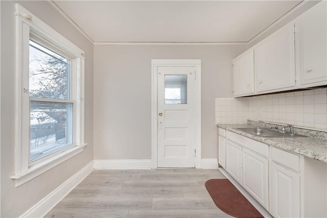 kitchen featuring light hardwood / wood-style floors, sink, white cabinets, and tasteful backsplash