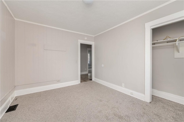 unfurnished bedroom featuring carpet, a closet, and crown molding