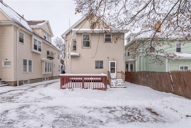 snow covered house featuring a deck