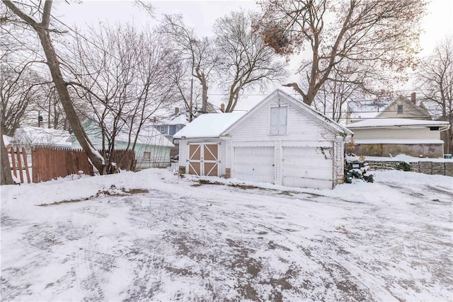 yard layered in snow with a garage and an outdoor structure