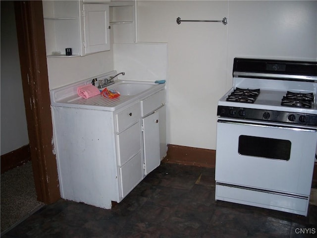 kitchen featuring white range with gas stovetop, sink, and white cabinetry