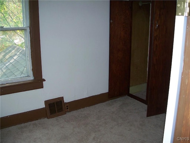 unfurnished bedroom with a closet and light carpet