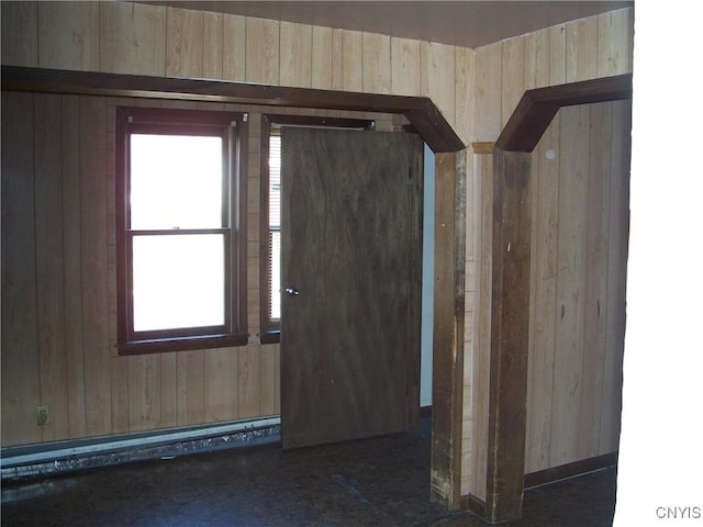 entryway featuring a baseboard heating unit and wooden walls