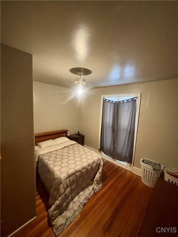 bedroom with dark hardwood / wood-style flooring