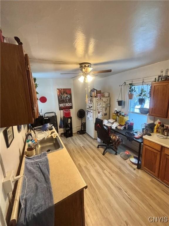 home office featuring light wood-type flooring and ceiling fan