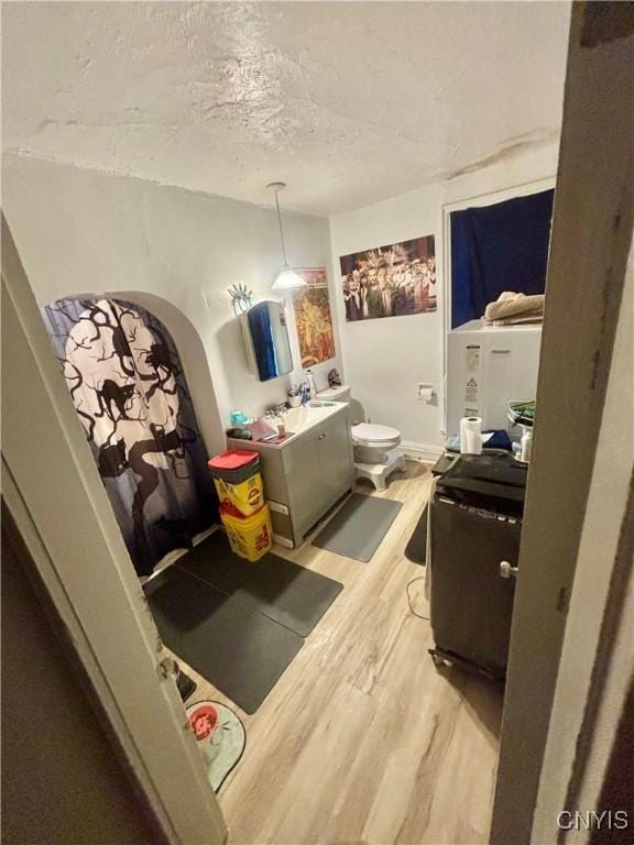 bathroom with vanity, toilet, a textured ceiling, and wood-type flooring