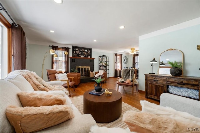 living room featuring a brick fireplace and light wood-type flooring