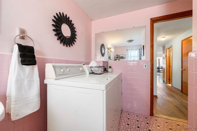 clothes washing area featuring tile walls and light tile patterned flooring