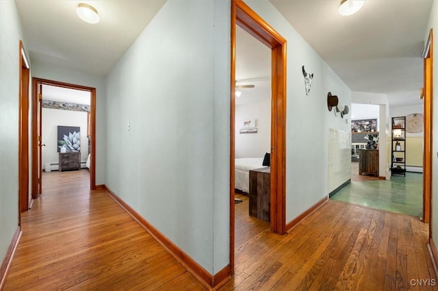 corridor with wood-type flooring and a baseboard radiator