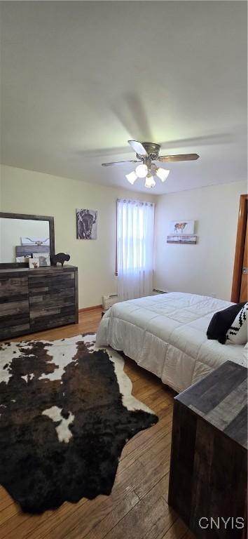 bedroom with ceiling fan and wood-type flooring