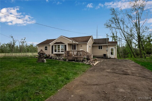 ranch-style house with a wooden deck and a front yard