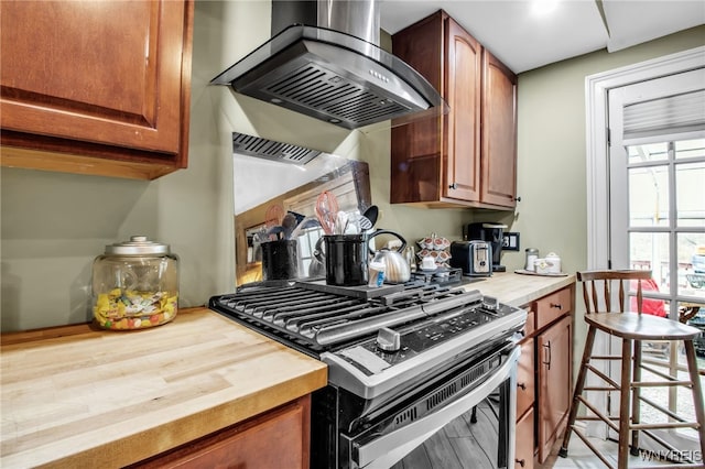 kitchen with stainless steel range with gas stovetop, light hardwood / wood-style floors, and extractor fan