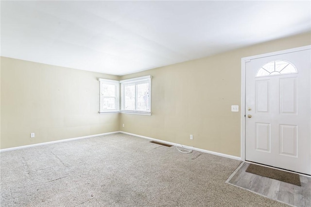 foyer entrance with carpet flooring and a healthy amount of sunlight