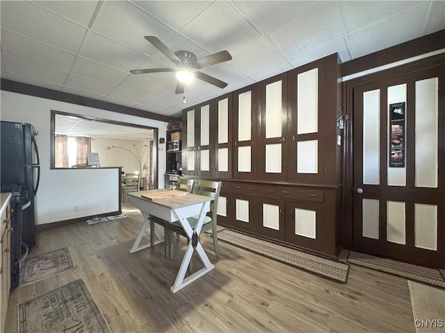 dining room with a paneled ceiling, hardwood / wood-style floors, and ceiling fan