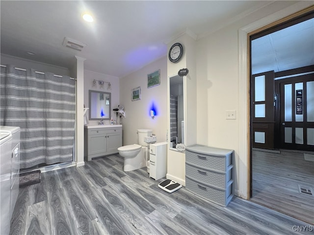 bathroom with walk in shower, toilet, crown molding, vanity, and hardwood / wood-style flooring