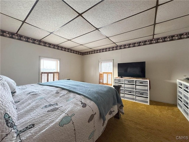 bedroom with a drop ceiling and carpet flooring