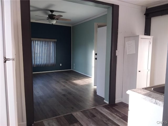 spare room with crown molding, dark wood-type flooring, and ceiling fan