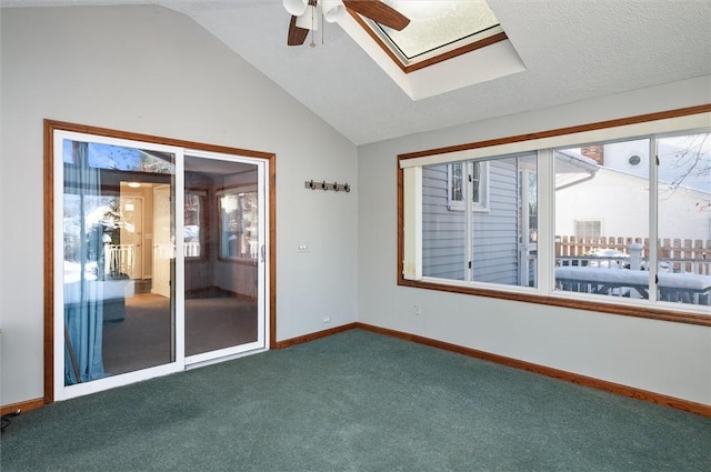 unfurnished room with ceiling fan, lofted ceiling with skylight, and carpet flooring